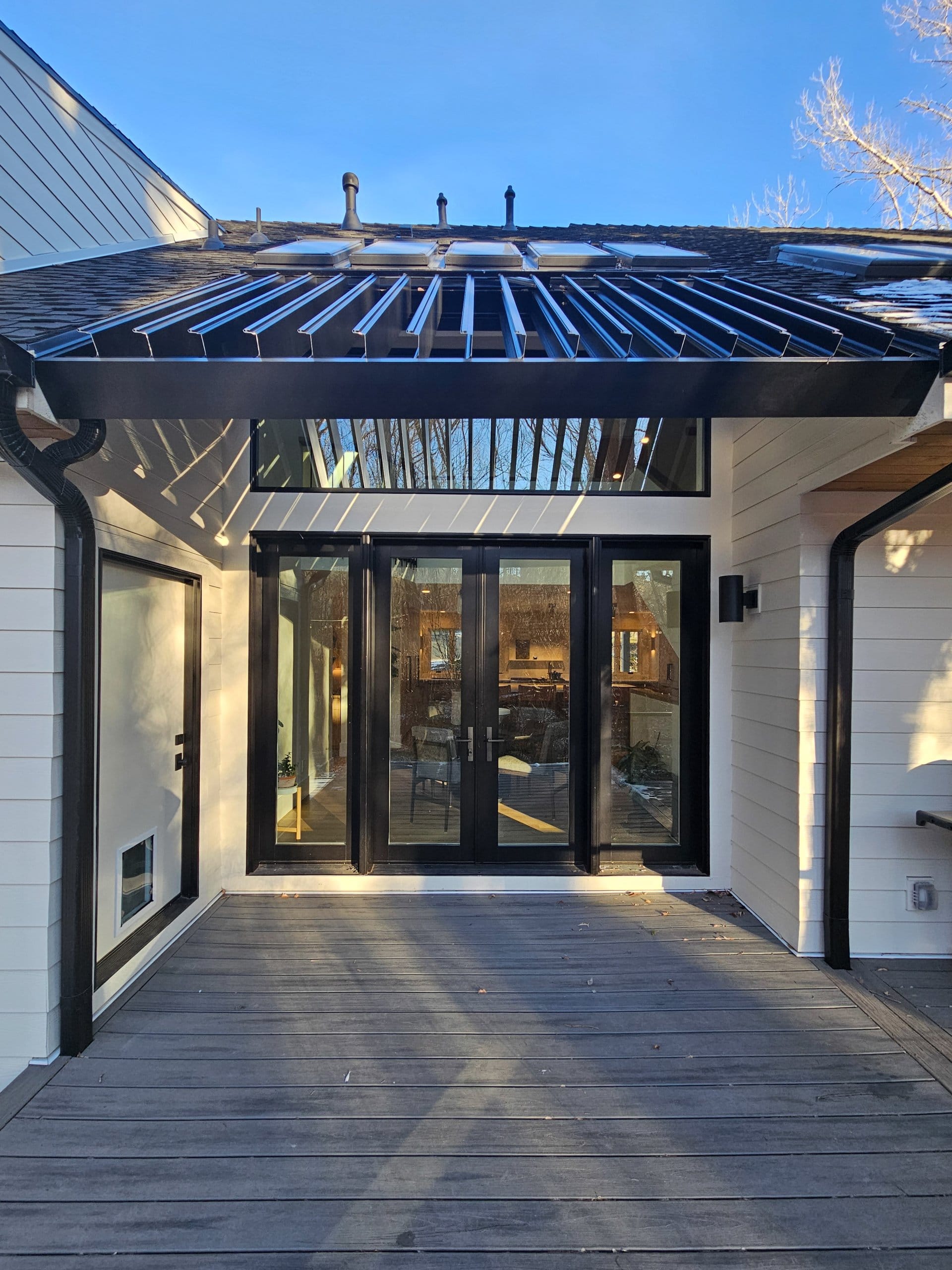 Back deck with entrances to the mudroom and dining room.