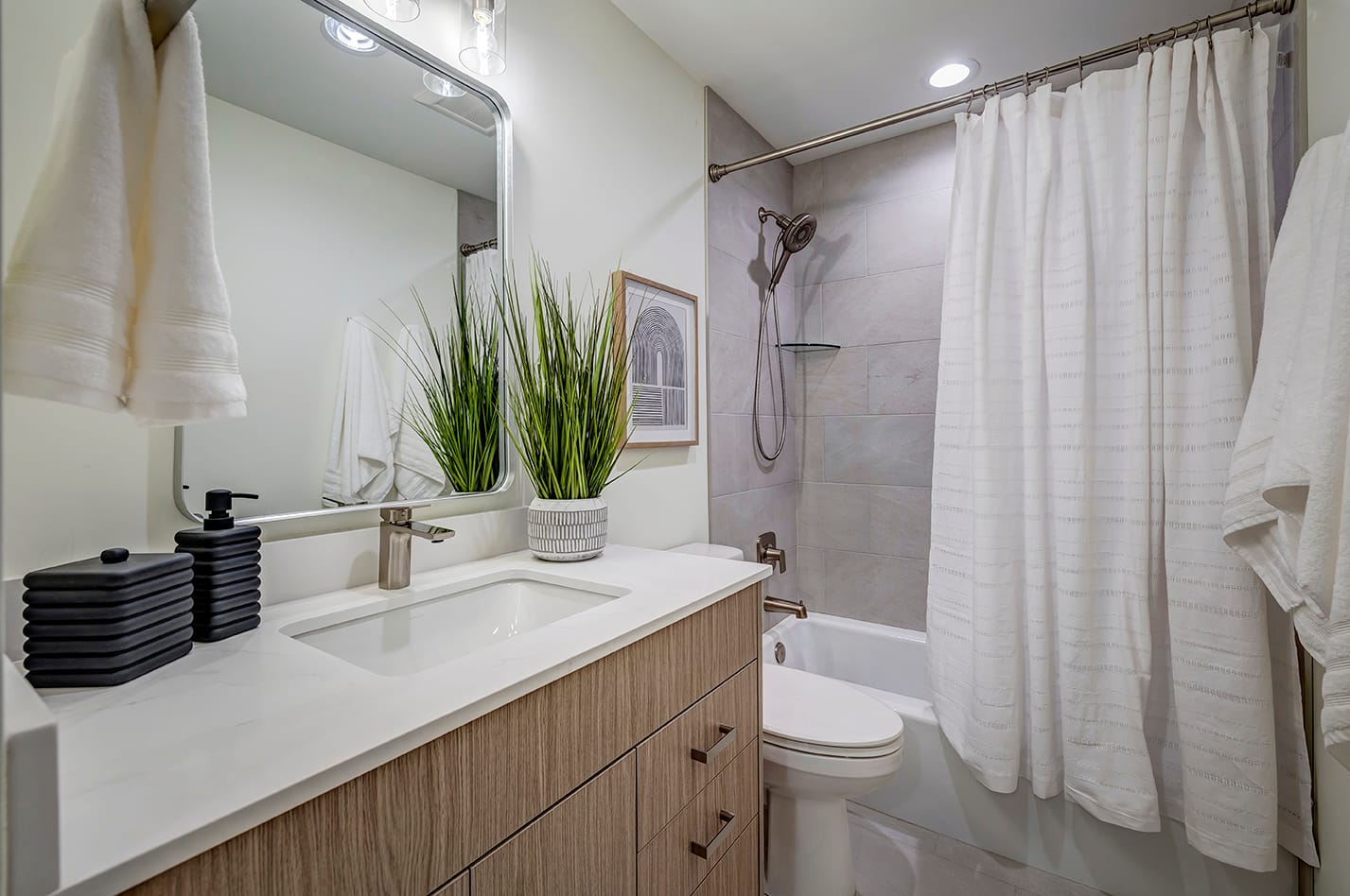 Updated bathroom with a sink, toilet, and shower and tub combination.