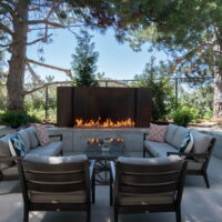 Thumbnail of http://Outdoor%20fireplace%20with%20two%20couches,%20chairs,%20and%20a%20coffee%20table%20in%20front.