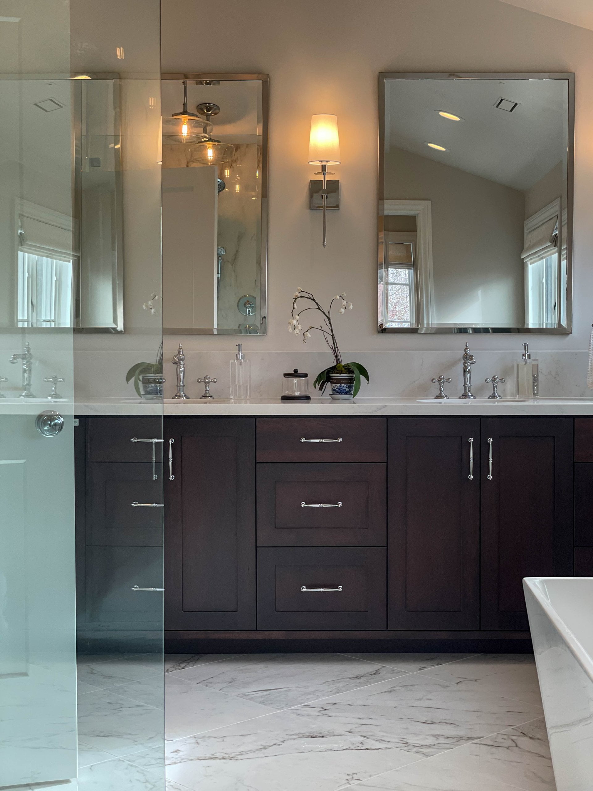 Primary bathroom with two sinks. On the counter are jars of soap and flowers.
