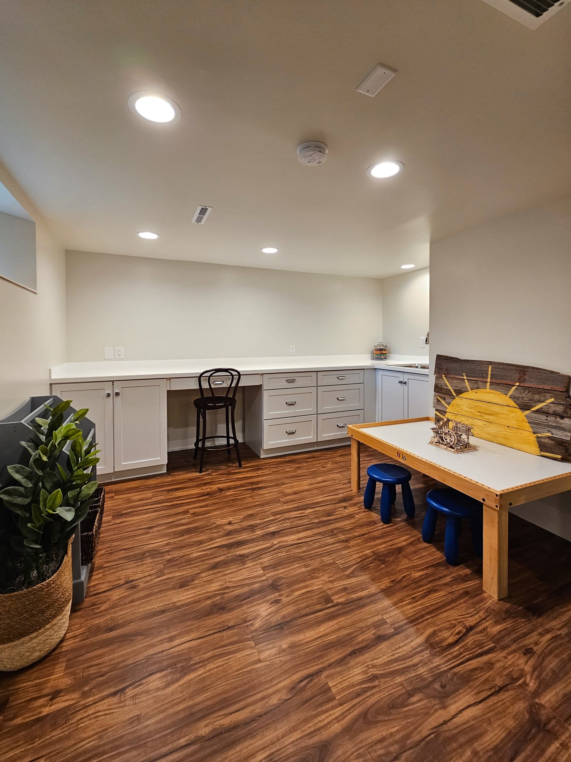 Custom basement craft room with built-in desks and storage.