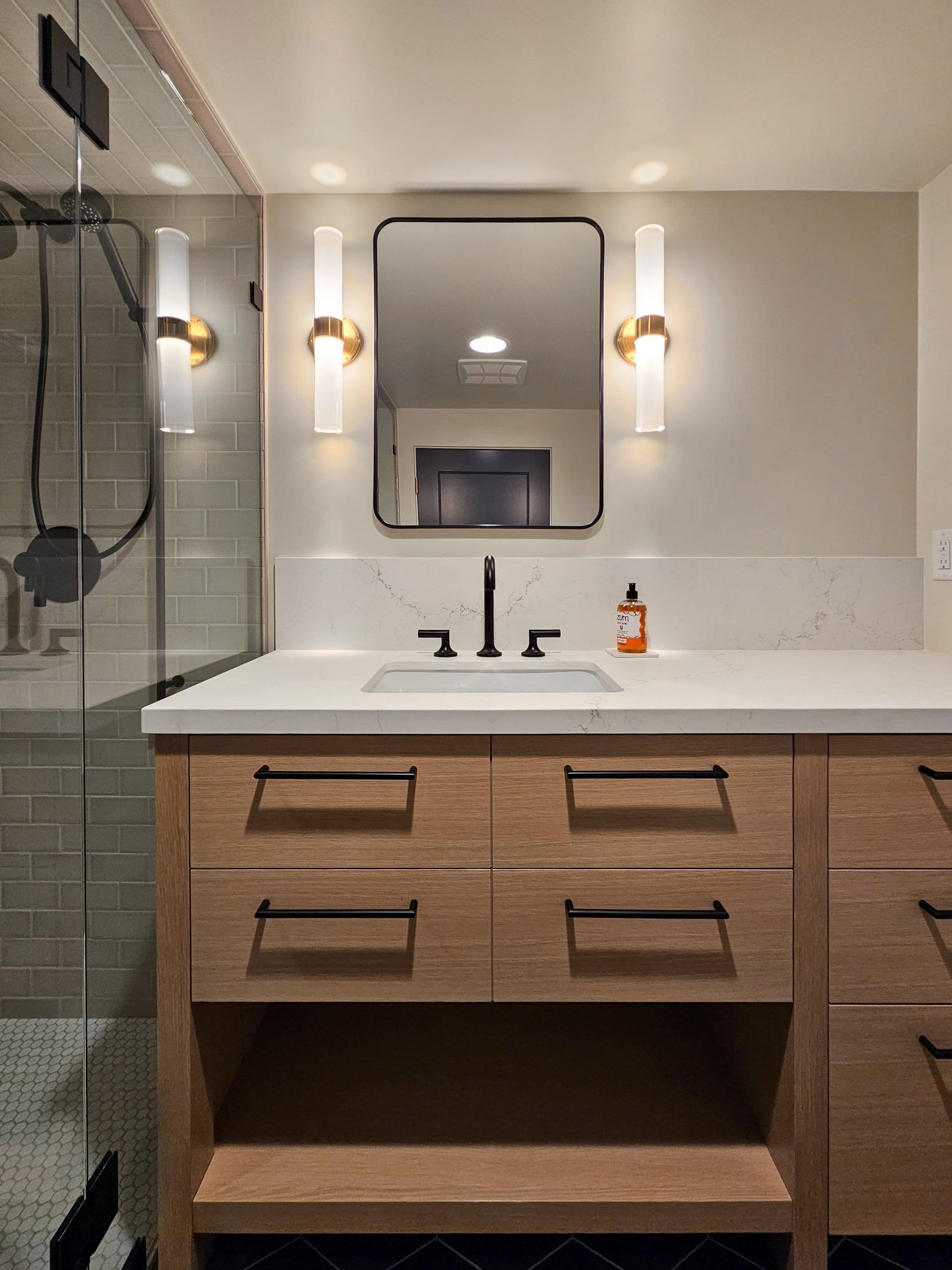 Modern bathroom vanity with storage, lighting, and a mirror centered above the sink.