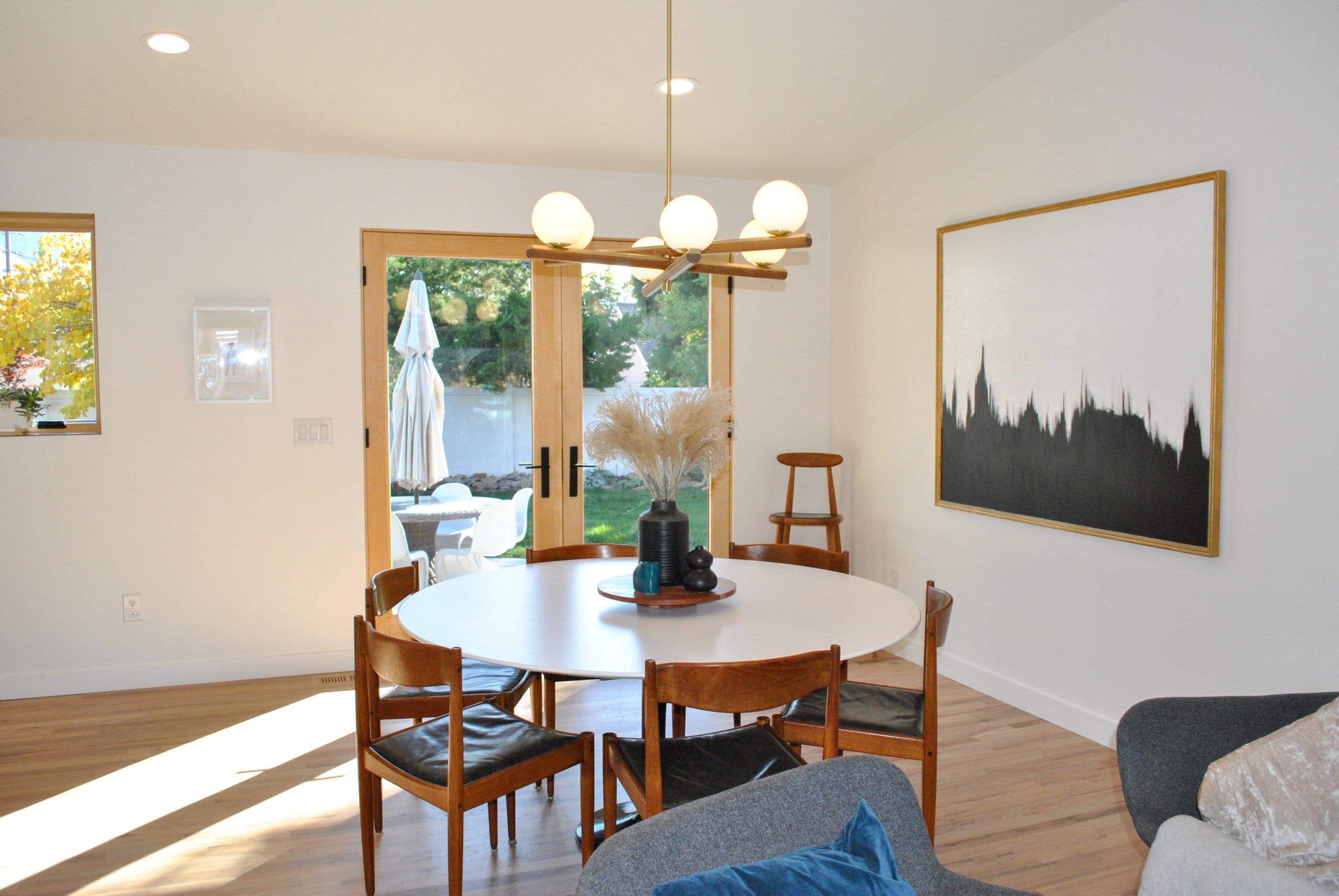 Dining room with a round table in the center that seats six and french doors behind.