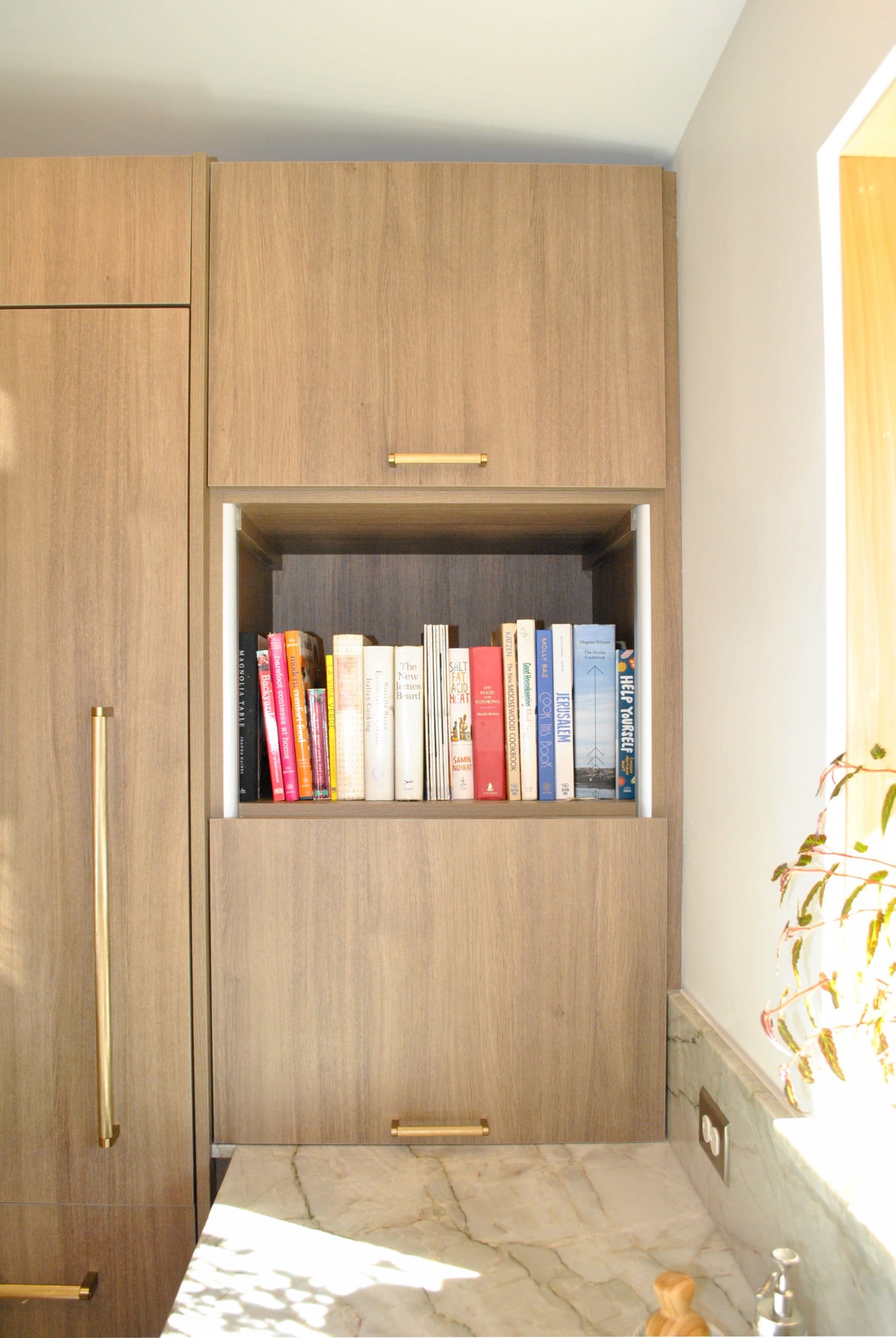 Kitchen shelf with cookbooks.
