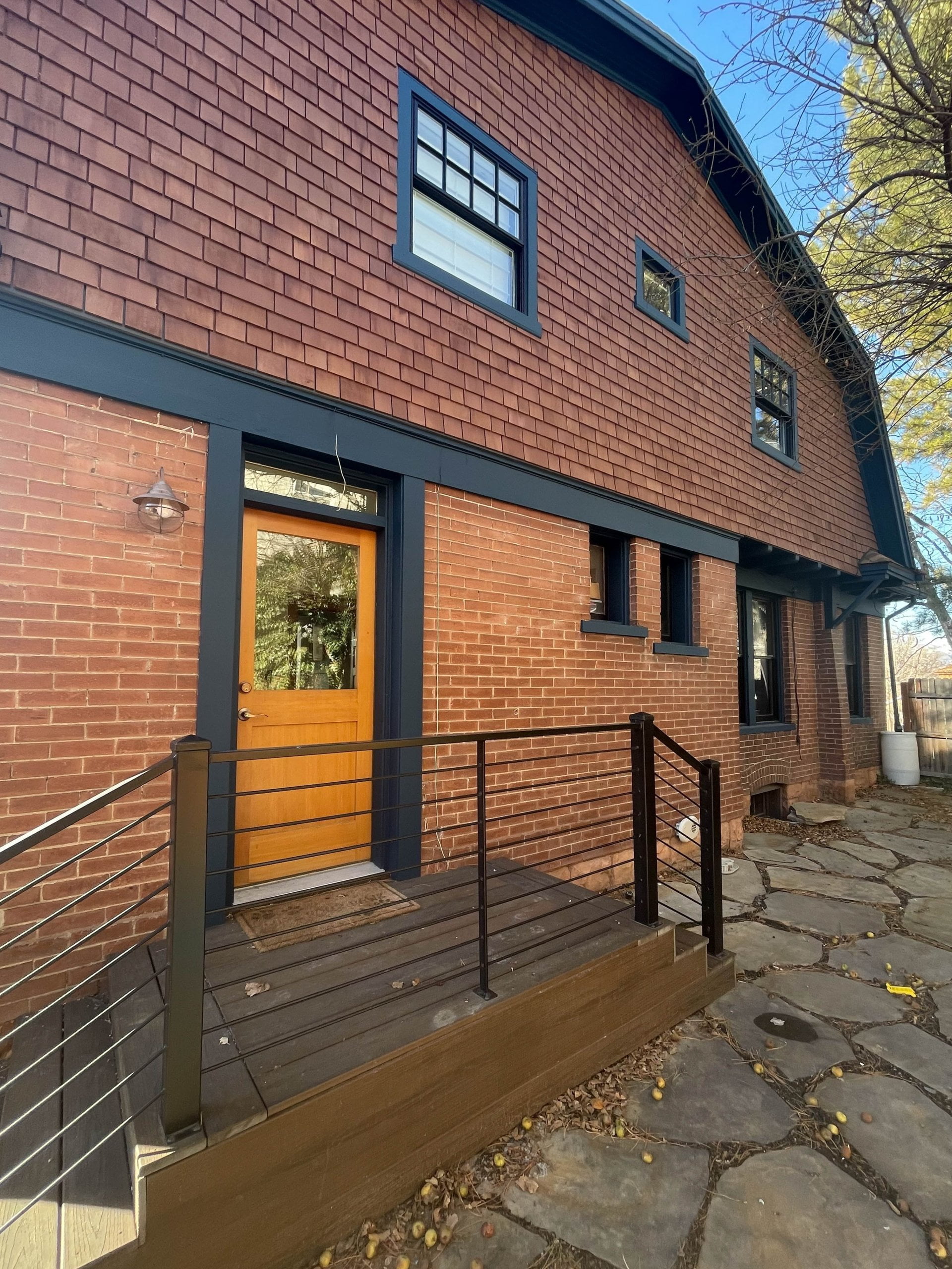 Side door at a historic home remodel with steps down two sides to a stone patio.
