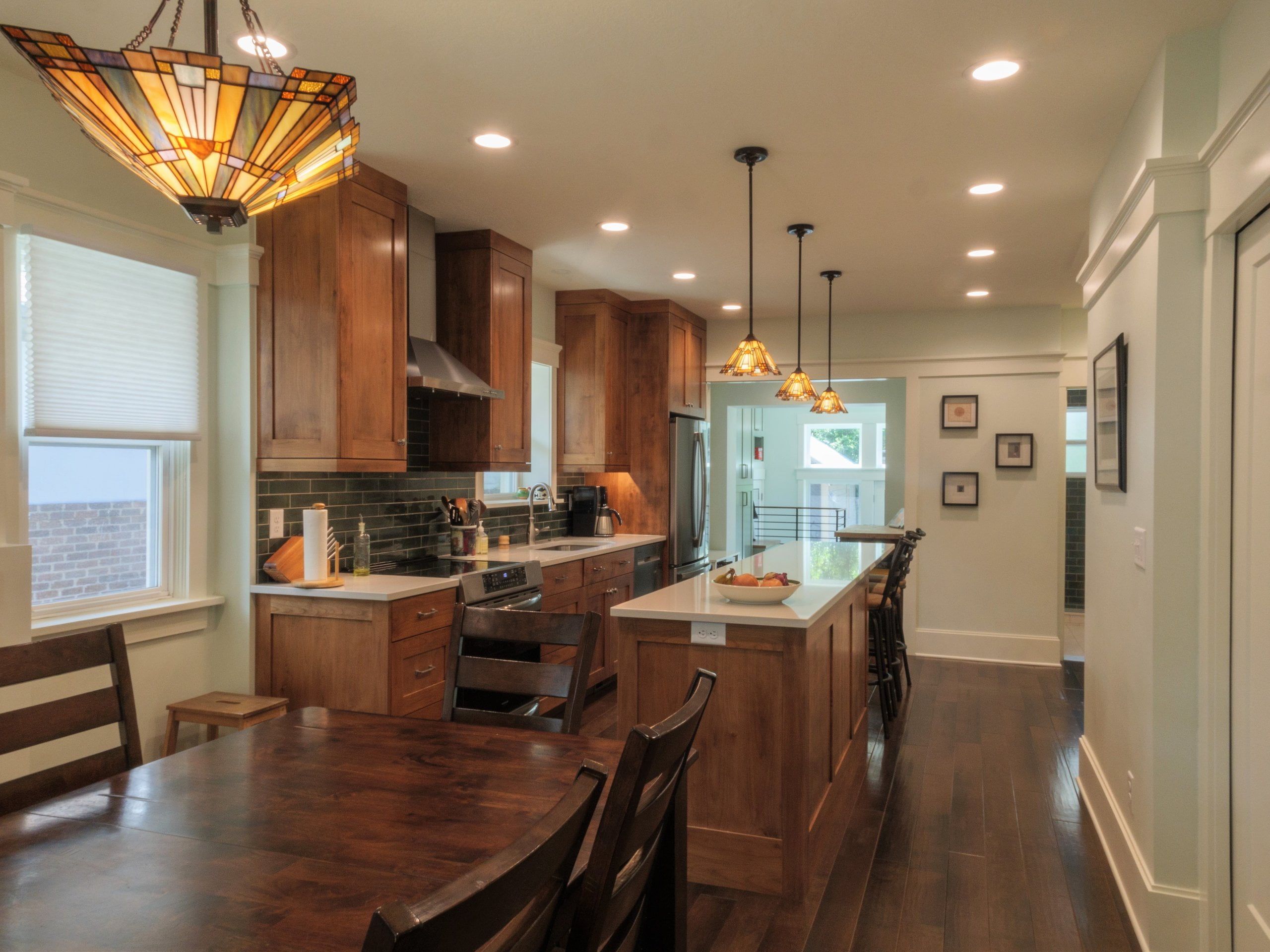 Open concept kitchen with long island in the center and fridge, dishwasher, sink, and range on the wall parallel.