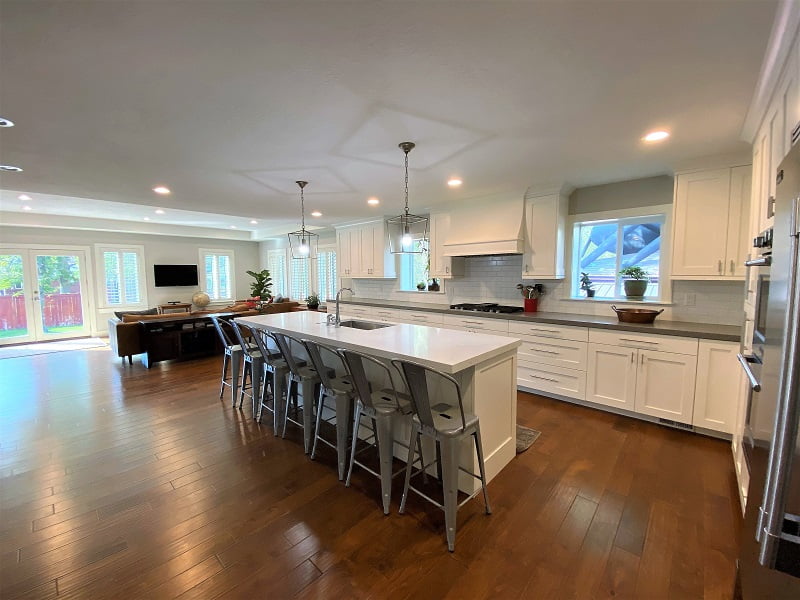 Large and open concept kitchen that includes double ovens, an island with seating for seven and a sink, and lots of storage.