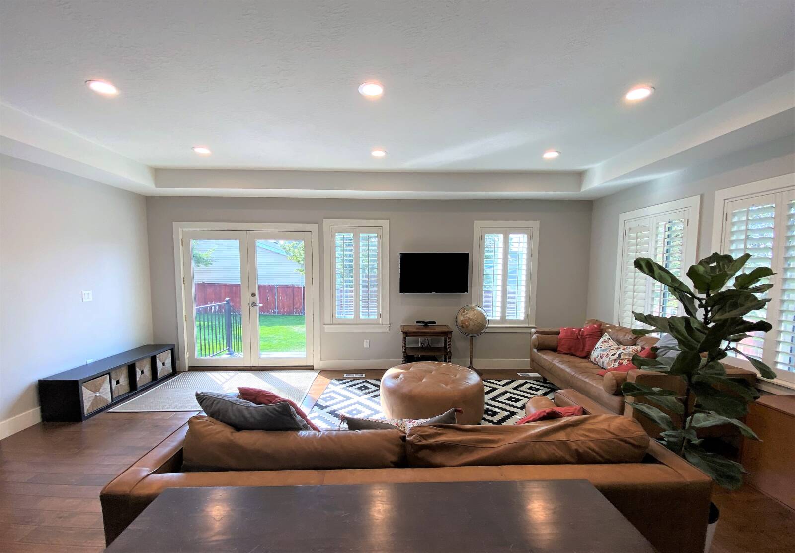 Open concept living room with furniture and doors to the backyard.