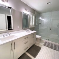Thumbnail of http://Primary%20bathroom%20remodel%20with%20two%20sinks,%20a%20toilet%20under%20the%20window,%20and%20a%20large%20shower.%20On%20the%20floor%20are%20three%20bath%20mats.