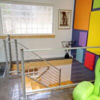 cable railing open stair contemporary vaulted ceiling, fireplace, living space contemporary vaulted ceiling, fireplace, living space kitchen island, bar stool, contemporary kitchen, lighting skylights and window natural light, glass table, rug Murphy Bed contemporary bed, casework, galvanized ceiling | Renovation Design Group