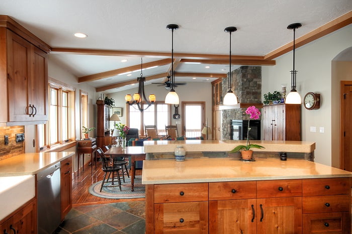 After_Interior_Great Room Designs_1980's Home Update_stone in the kitchen_Tile and wood flooring together_pendulum lights_Kitchen island bar_Bar stools_Window Seats | Renovation Design Group