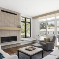 Thumbnail of http://Modern%20living%20room%20that%20features%20a%20door%20to%20the%20balcony%20and%20a%20fireplace%20with%20a%20long%20bench%20seat%20in%20front%20of%20a%20window.