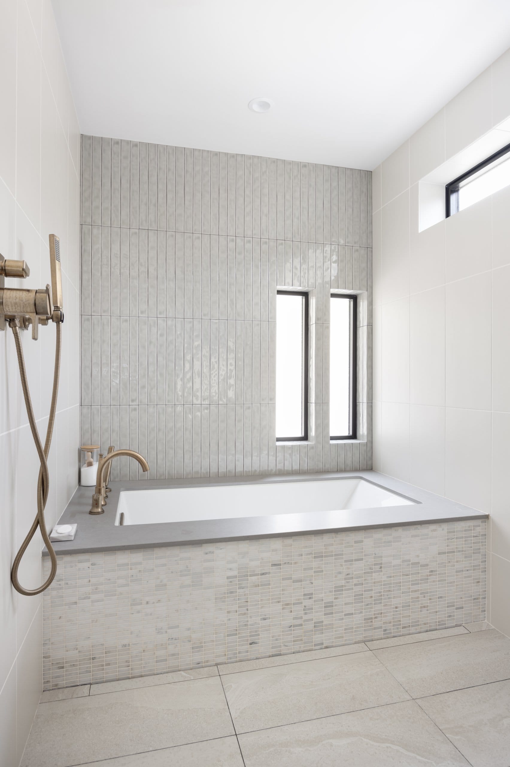 Modern primary bathroom wet room for the shower and large tub featuring a neutral design and narrow windows.