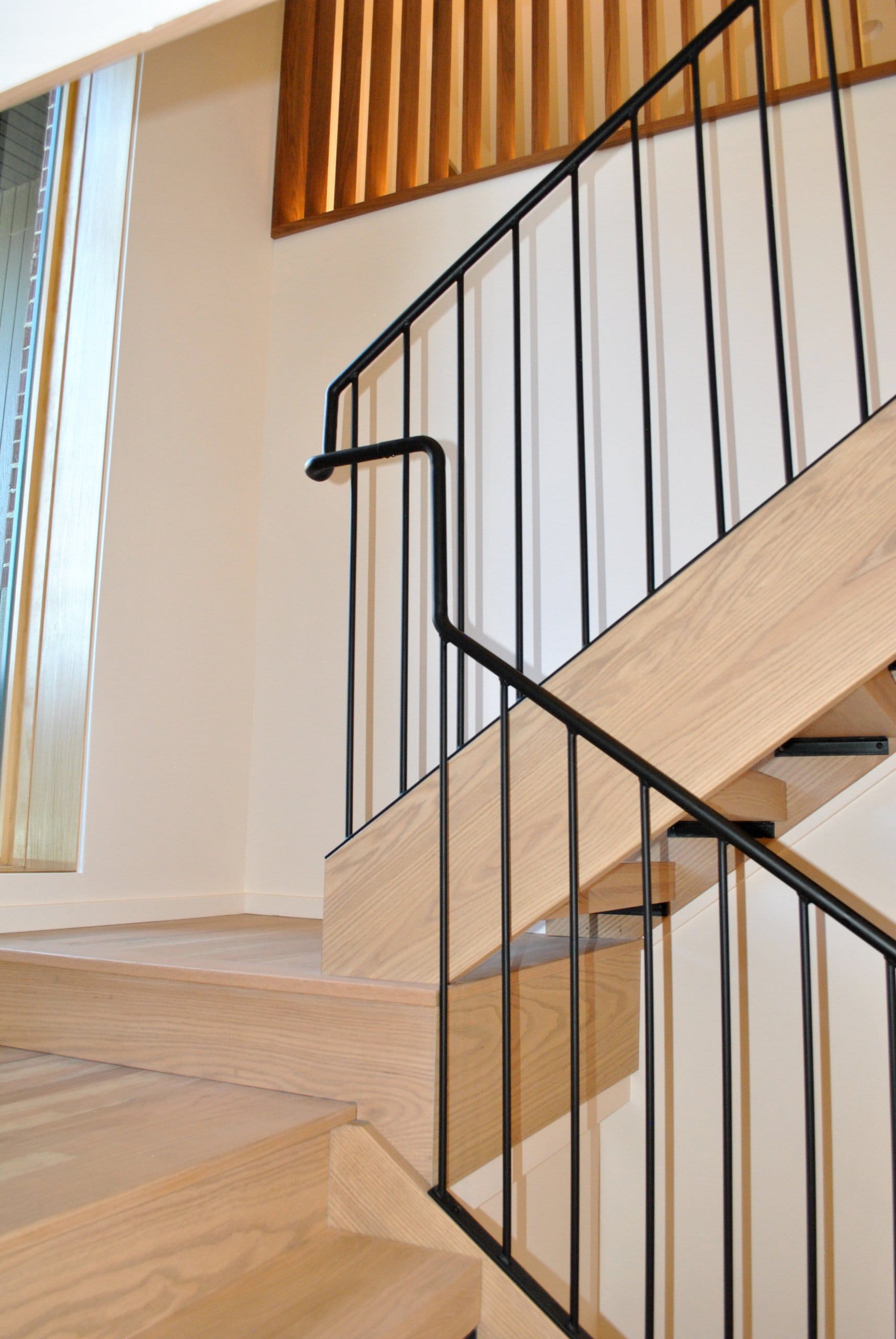 Stair with metal railing and window at the landing.