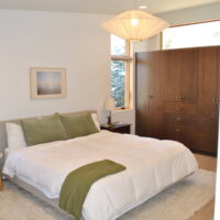 Thumbnail of http://Primary%20bedroom%20with%20a%20mid-century%20modern%20design%20and%20cabinets%20for%20a%20built-in%20closet.