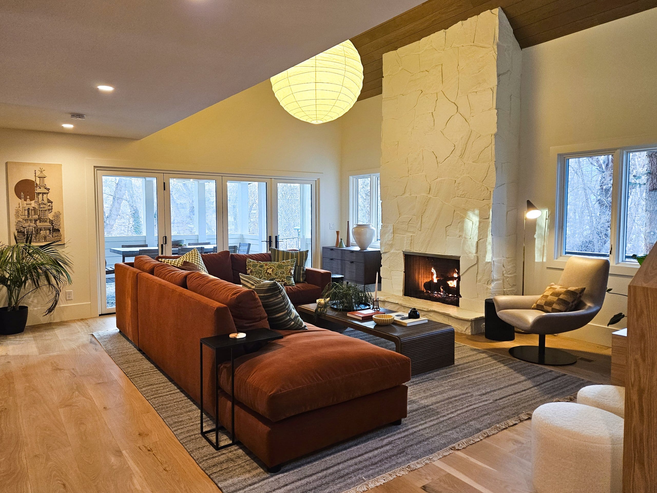 Living room with large couch, fireplace, and natural light from the windows.