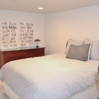 Thumbnail of http://Bedroom%20with%20a%20large%20bed%20and%20dresser.%20Above%20the%20dresser,%20two%20pictures%20with%20text%20are%20hung.