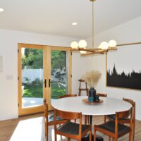 Thumbnail of http://Dining%20room%20with%20a%20round%20table%20in%20the%20center%20that%20seats%20six%20and%20french%20doors%20behind.