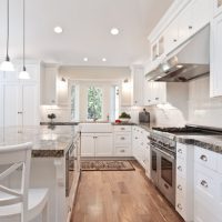 Large Kitchen with white cabinets and hardwood floors and farm sink | Renovation Design Group