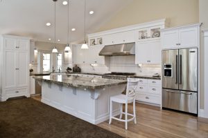 Open Kitchen with modern traditional white cabinets and a high ceiling with a large kitchen island | Renovation Design Group