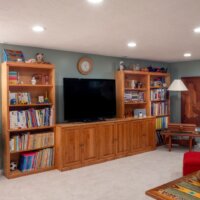 Thumbnail of http://Basement%20family%20room%20with%20wood%20bookcases%20and%20TV%20cabinet%20along%20the%20wall.