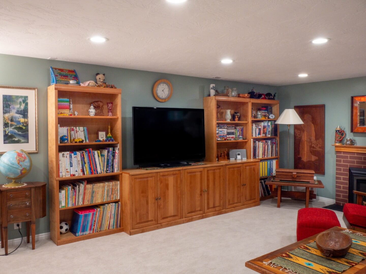 Basement family room with wood bookcases and TV cabinet along the wall.