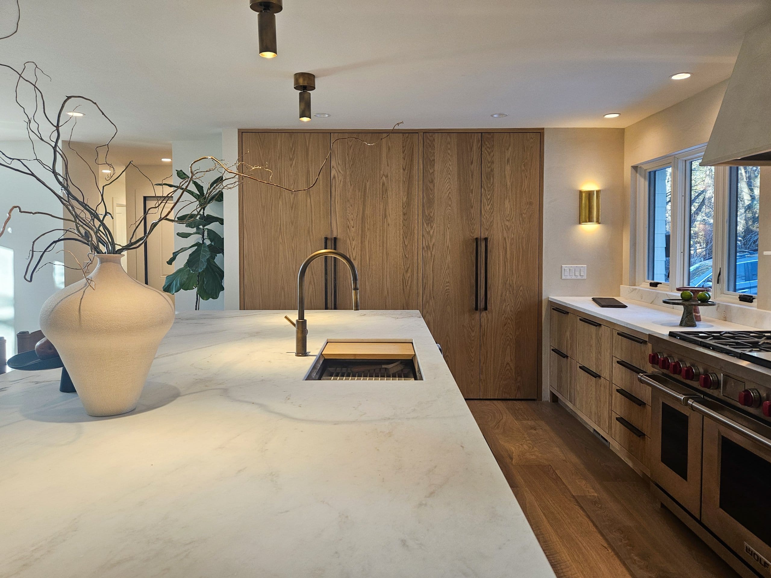 Kitchen island with sink, built-in fridge and freezer combination, and a hidden pantry.