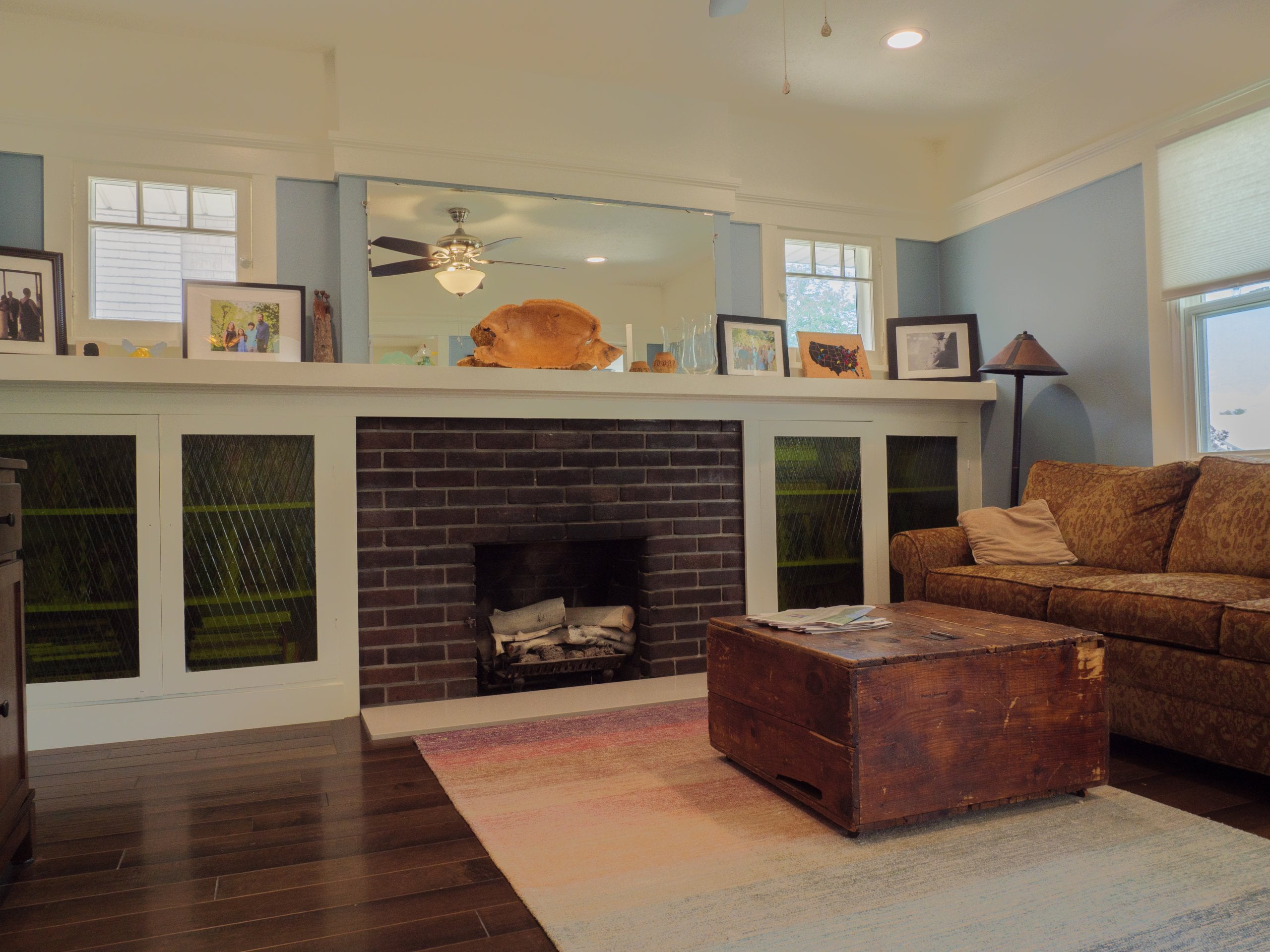 Family room with a fireplace, built-in bookcases, coffee table, and couch under the windows.