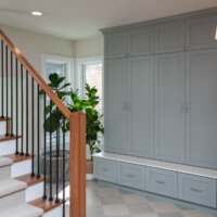 Thumbnail of http://A%20staircase%20with%20a%20mudroom%20on%20the%20other%20side%20of%20the%20railing.%20The%20mudroom%20includes%20large%20built-in%20cabinets,%20plants,%20and%20tile%20flooring.