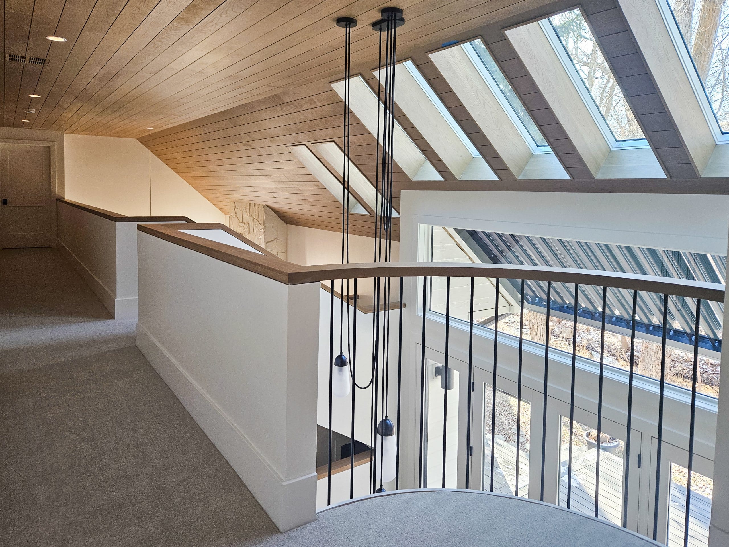 Upstairs hallway with partial wall and railing looking toward the skylights.