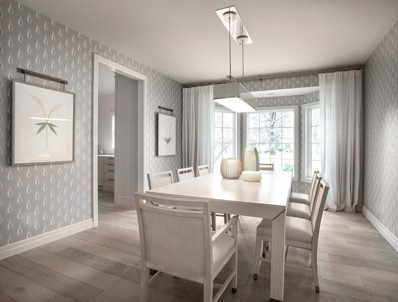Formal Dining room with seating for eight and a white and gray color palette, bay window, and contemporary light fixture.