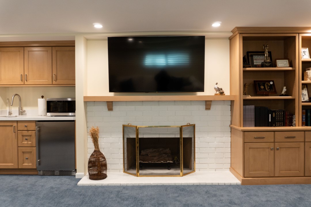 Brick fireplace with TV above and cabinets built-in on either side