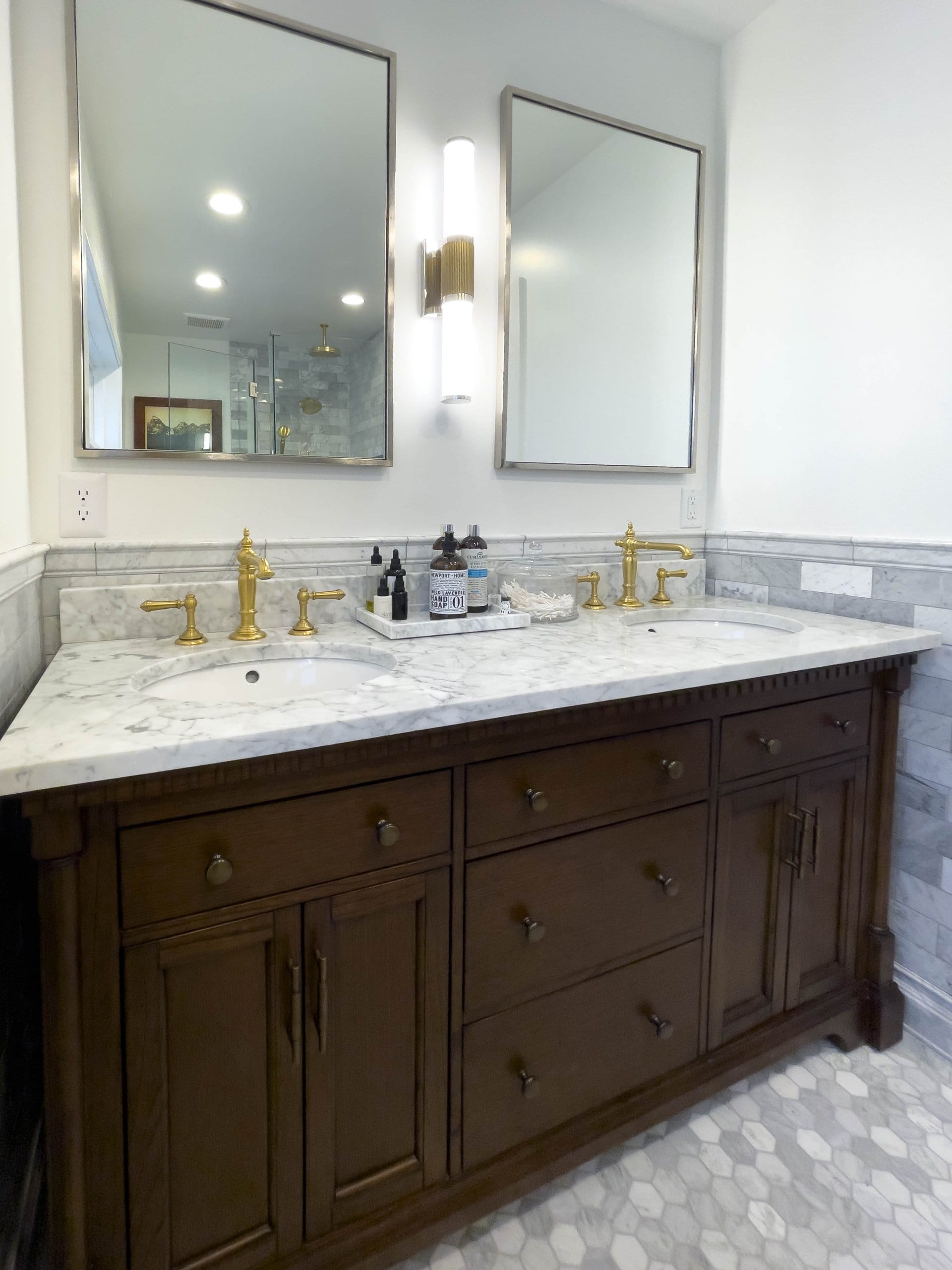Primary bathroom double sink vanity with mirrors hung on the wall above each sink.