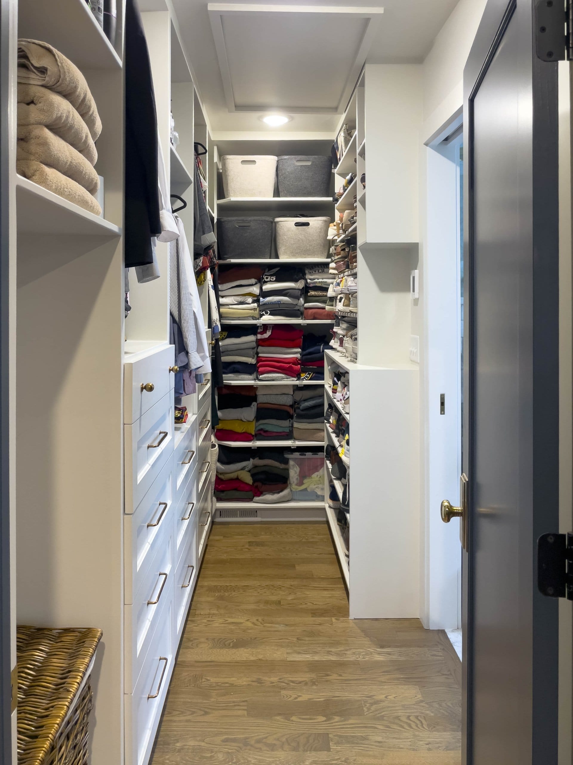 Walk-through closet with cabinetry.
