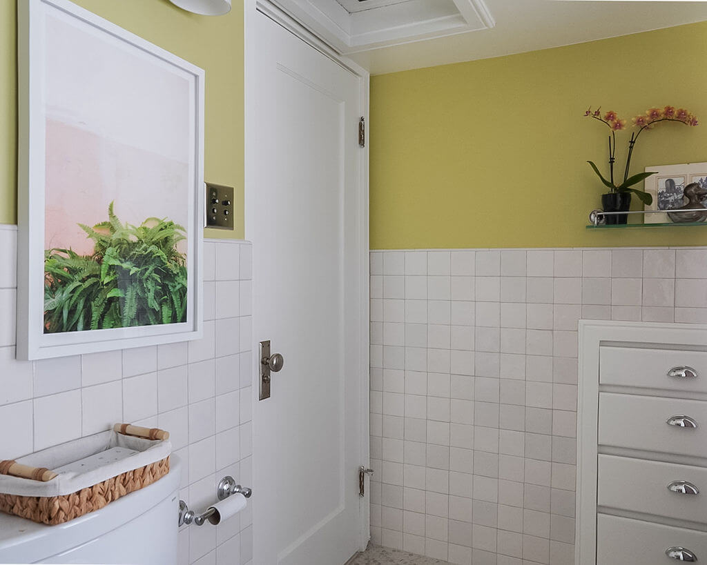Door to the bathroom with a picture hung on the wall to the side.