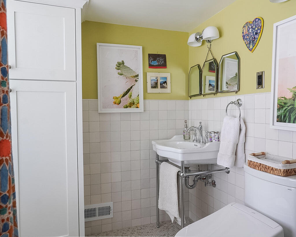 Renovated bathroom with storage cabinet, sink, and toilet.
