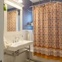 Thumbnail of http://Renovated%20bathroom%20with%20a%20sink%20and%20tub.%20The%20tub%20is%20blocked%20by%20a%20shower%20curtain.