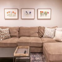 Thumbnail of http://Family%20room%20with%20couch%20and%20three%20pictures%20hanging%20above.