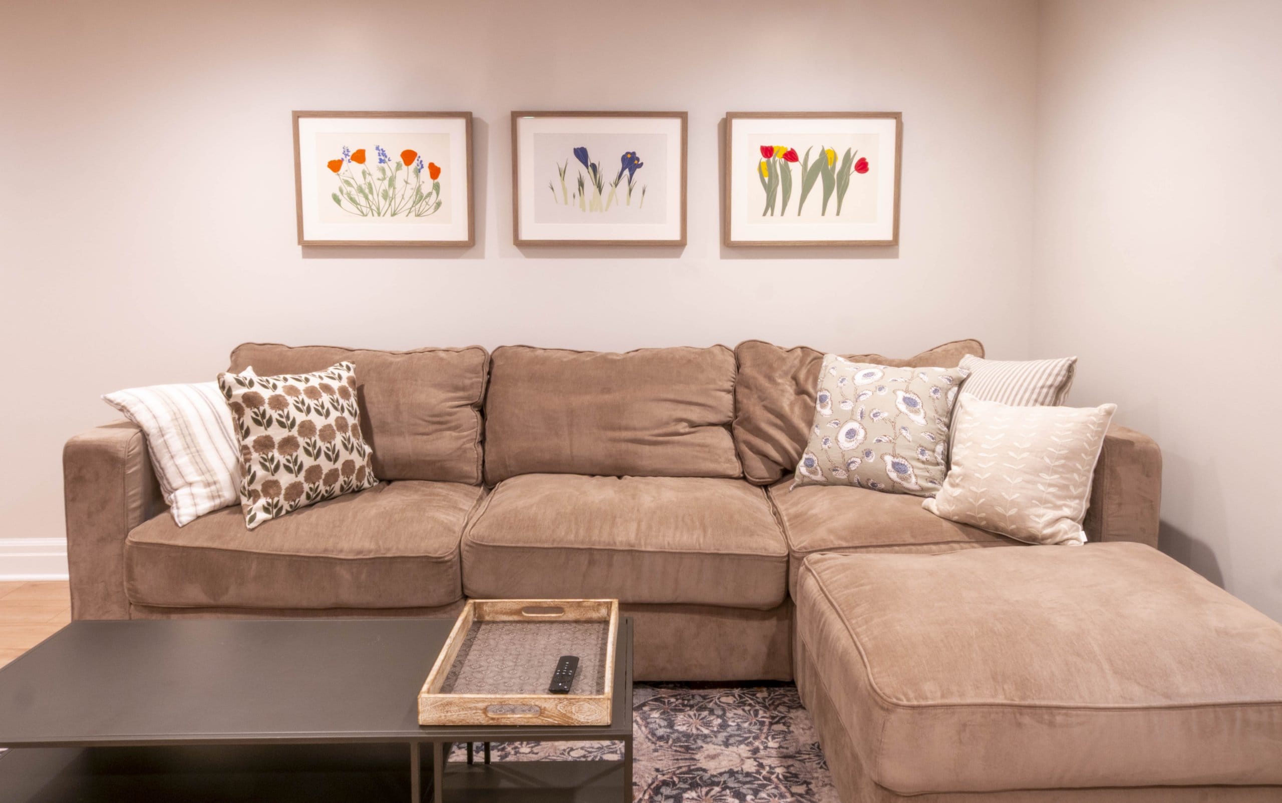 Family room with couch and three pictures hanging above.