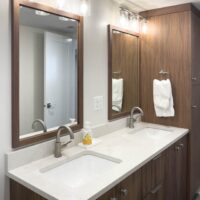 Thumbnail of http://Two%20sinks%20in%20a%20bathroom%20with%20mirrors%20and%20lights%20above.