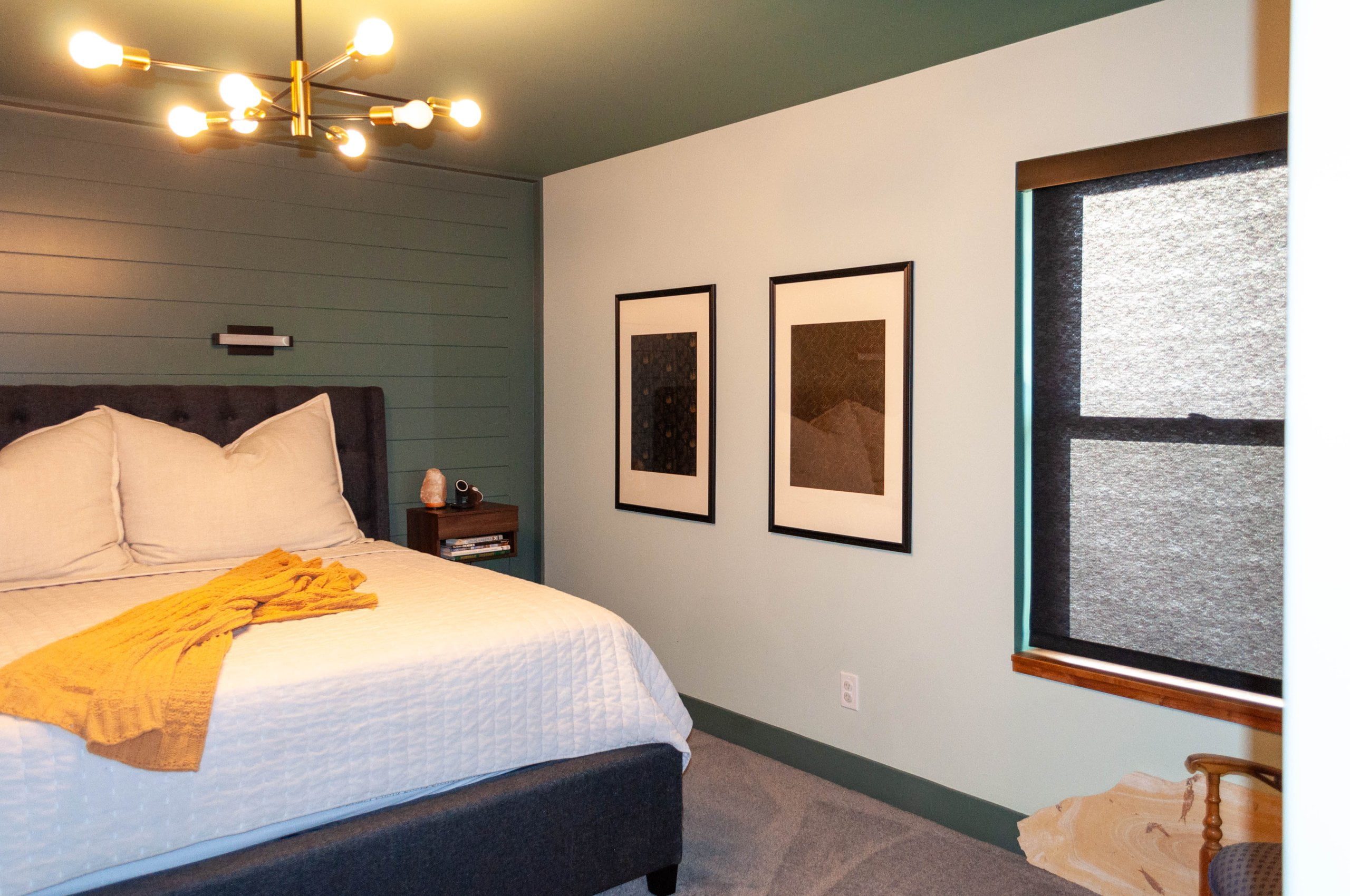 Primary bedroom with green walls, trim, and ceiling. The room is furnished with a large bed and built-in nightstand.