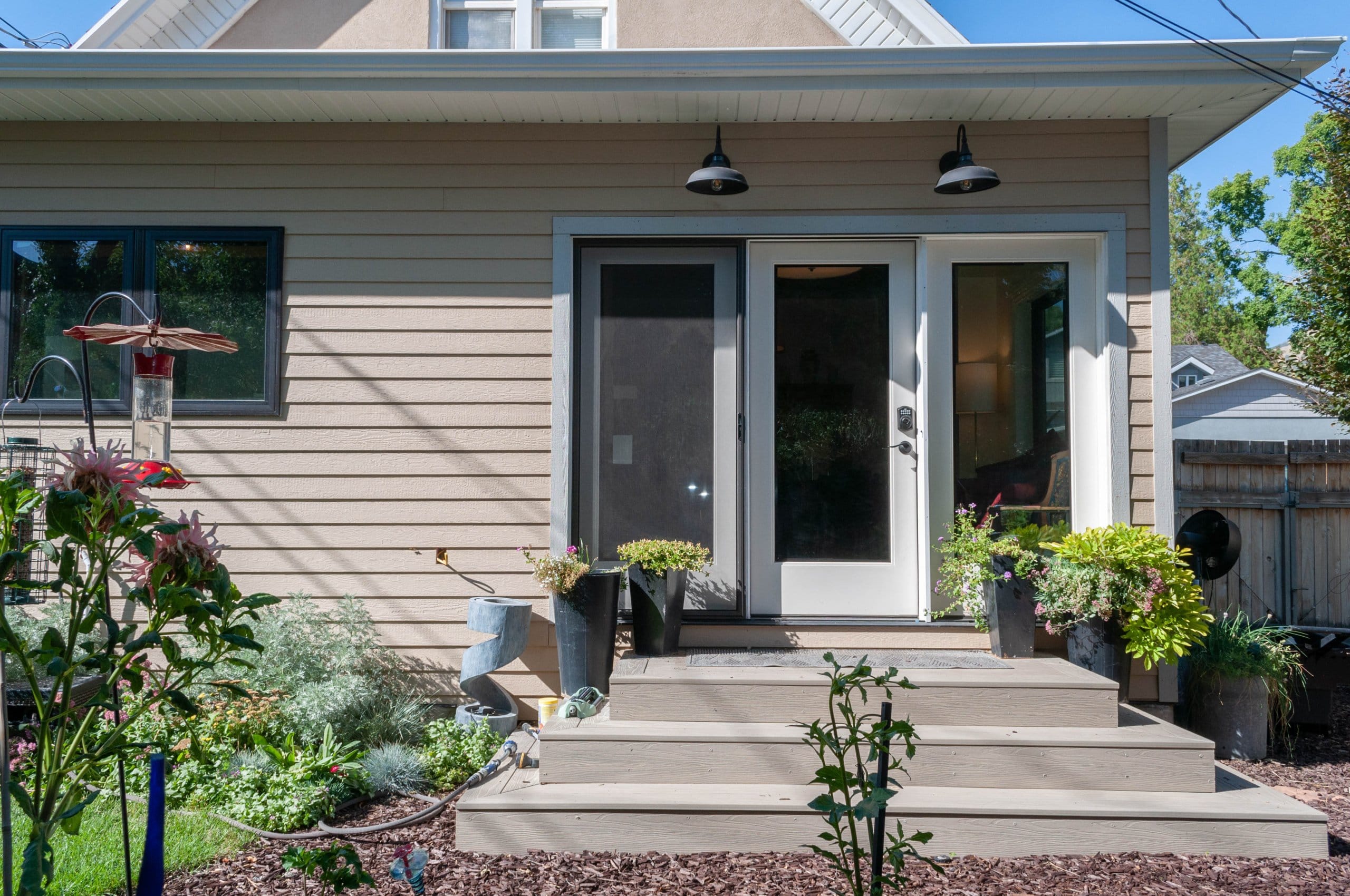 Exterior of the addition with new landscaping. The addition includes a new back door with three steps leading to the yard.