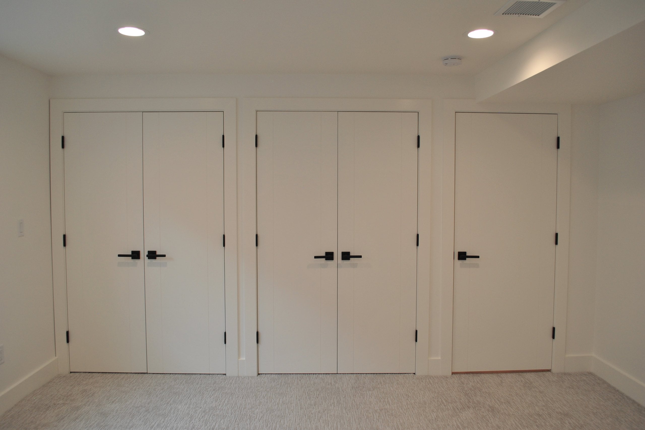 Wall of doors including two sets of double doors and one single door.