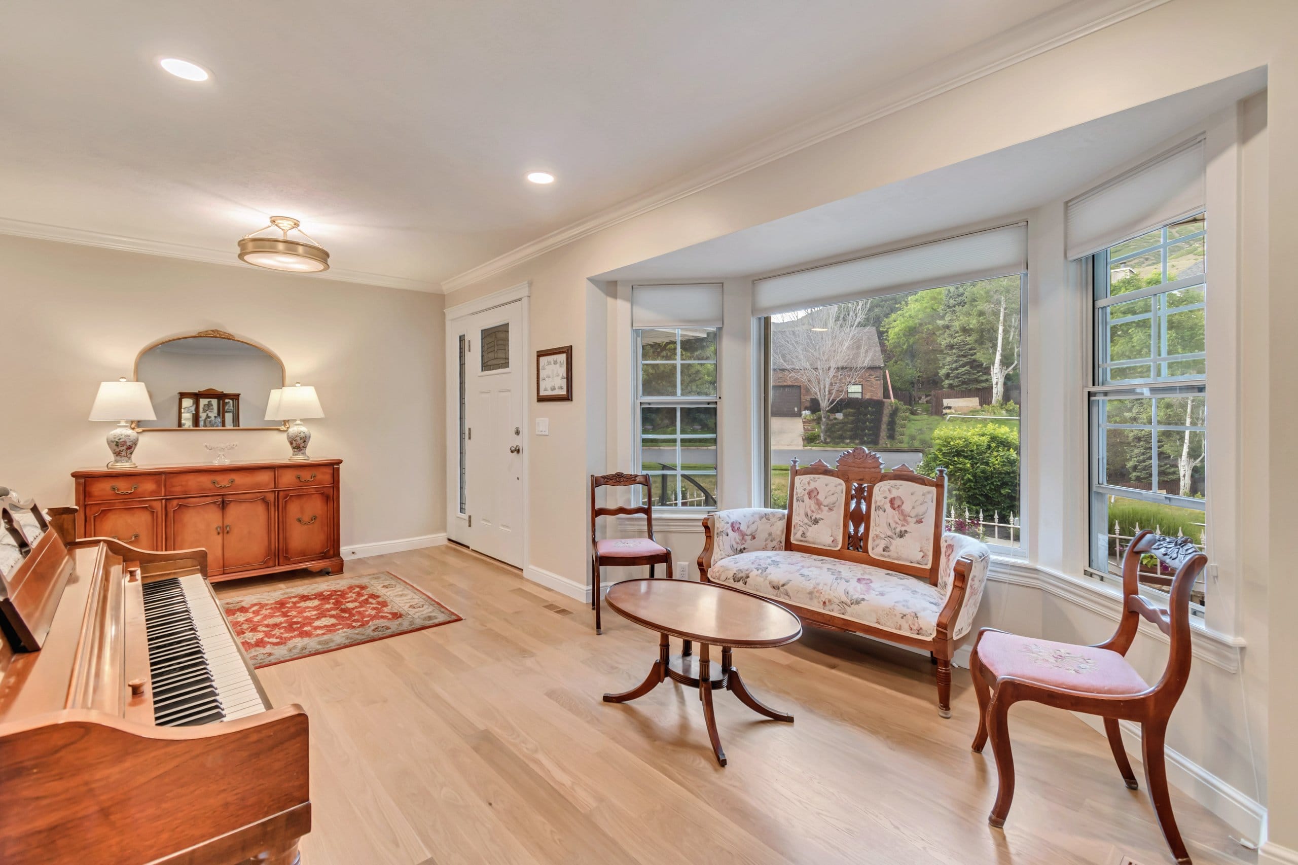 Formal living room with a bay window and piano.