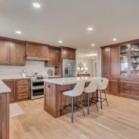 Thumbnail of http://Kitchen%20with%20wood%20cabinetry,%20an%20island,%20and%20a%20wall%20of%20pantry%20storage.