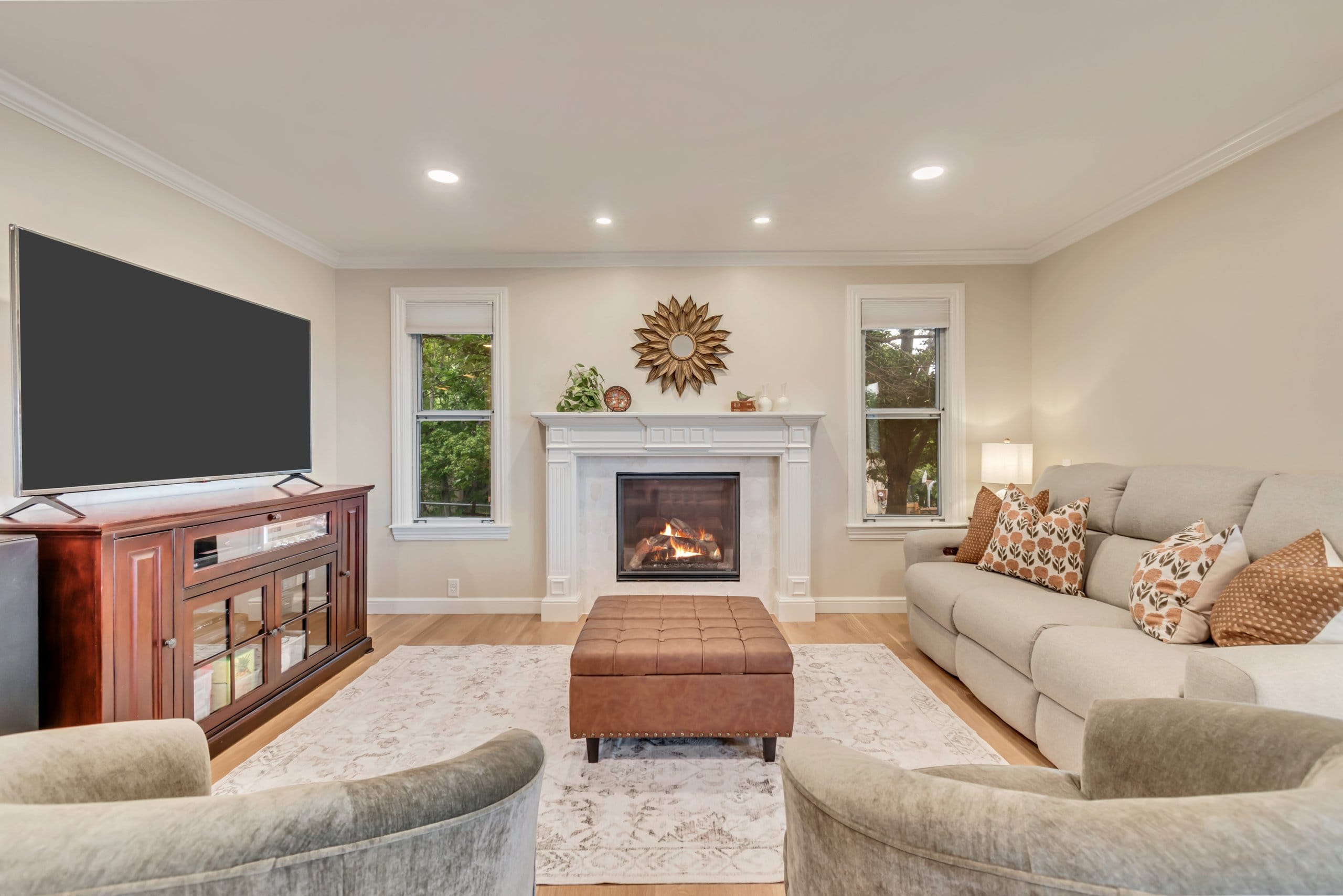 Family room fireplace with windows on either side and seating in front.