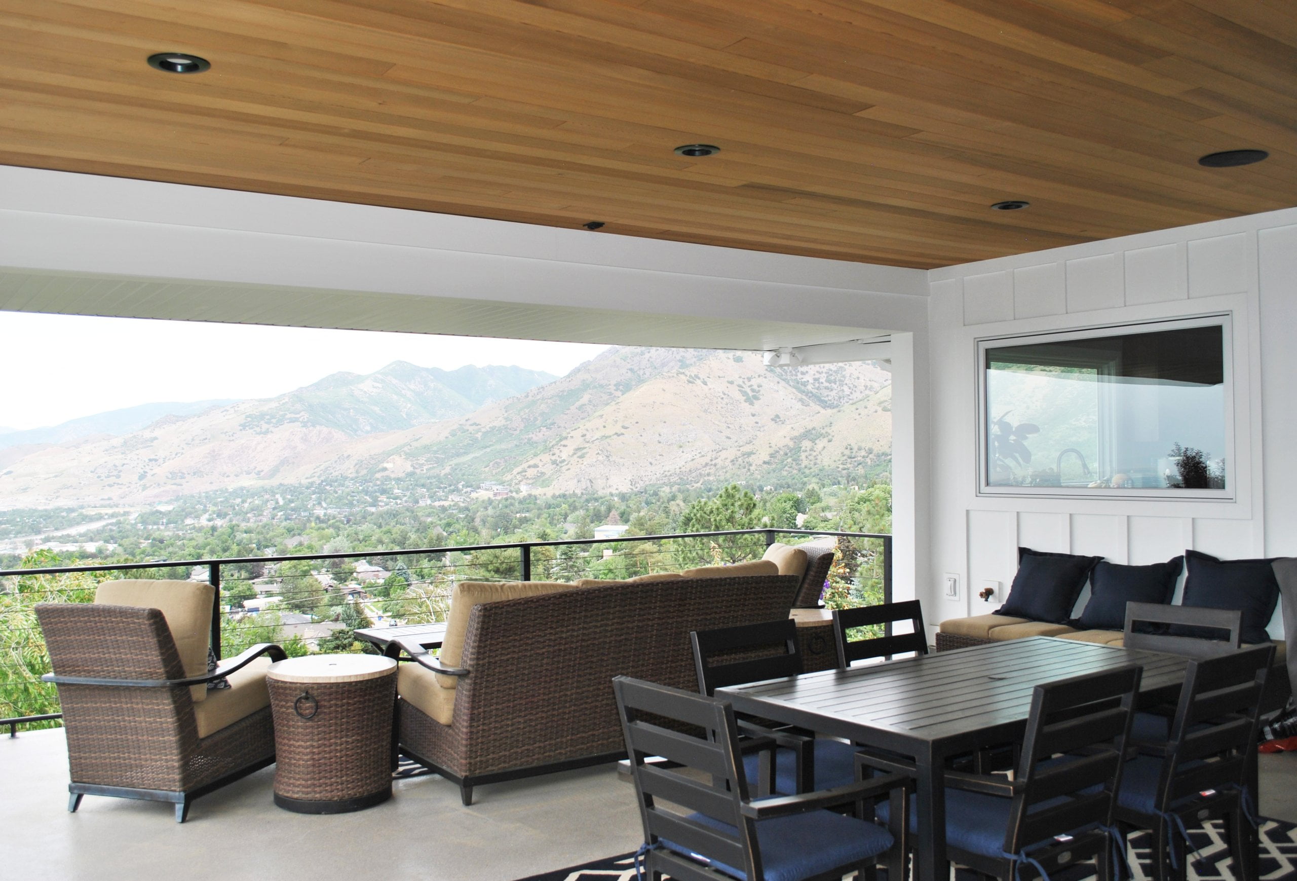 Covered deck with outdoor furniture and a view of the mountains.