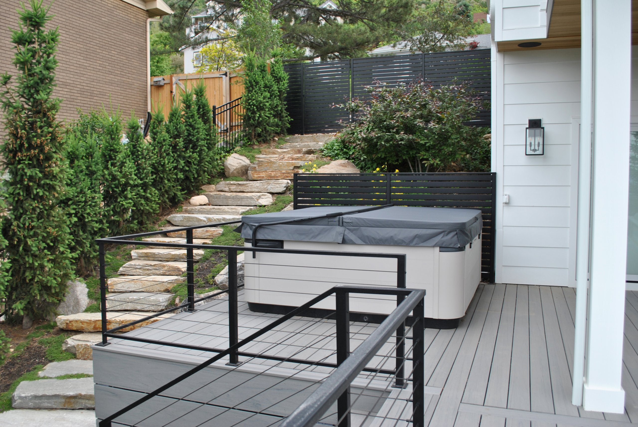 Deck with a railing and hot tub.