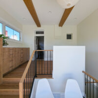 Thumbnail of http://Large%20mudroom%20and%20laundry%20room%20addition%20with%20staircase.%20The%20space%20includes%20two%20chairs%20in%20a%20little%20alcove%20on%20the%20staircase%20landing%20and%20built-in%20cabinets%20along%20the%20exterior%20wall.%20Straight%20ahead%20is%20a%20brick%20wall%20with%20a%20door%20to%20the%20kitchen.