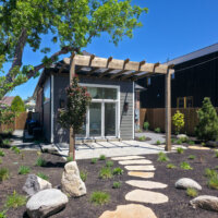 Thumbnail of http://Exterior%20of%20the%20addition%20featuring%20new%20landscaping%20that%20includes%20various%20plants,%20a%20stone%20path,%20and%20a%20patio%20with%20a%20pergola.